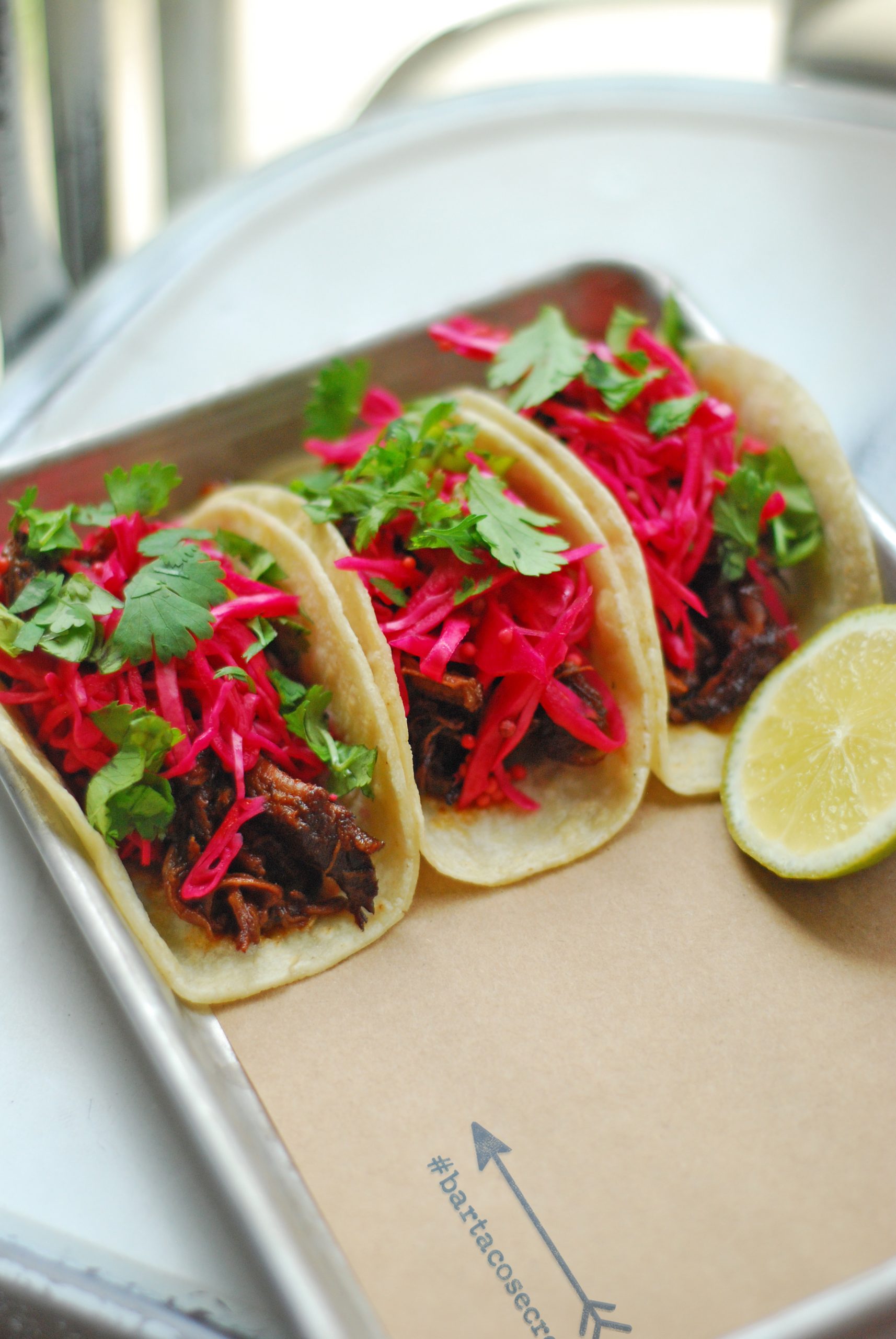 close up image of the #bartacosecret ancho-braised beef taco, now available at order.bartaco.com